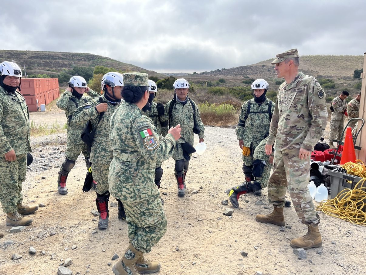 Andrew Leonard giving field instruction to partner-nation rescue personnel